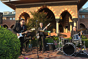 Rock band playing music on the patio outside of the Clubhouse