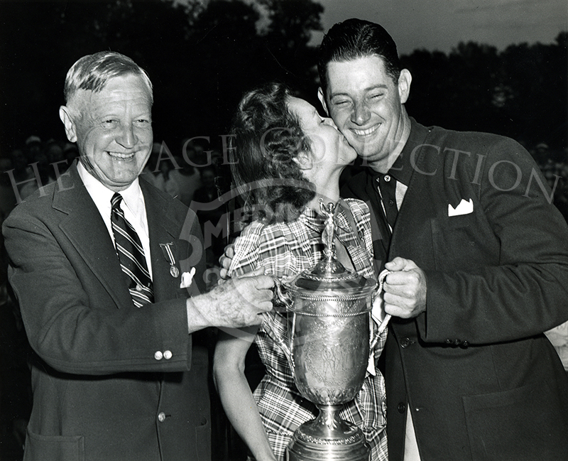 Dr. Cary Middlecoff, photographed after winning the 49th U.S.Open in 1949, received a kiss from wife Edith and the tournament trophy from Fielding Wallace, president of the Western Golf Association.