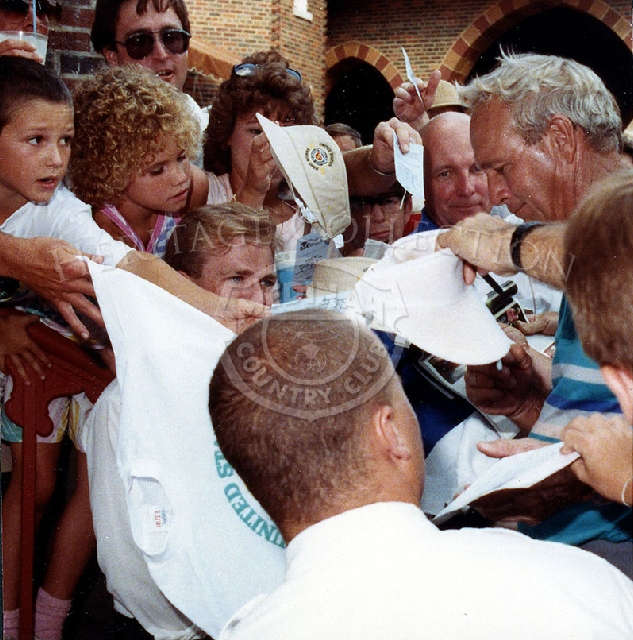Surrounded by his admirers, Arnold Palmer signs autographs before play at the Ninth U.S. Senior Open Championship. Although Palmer did not place in the top ten after completion of the tournament, he had the longest measured drive on the seventh hole when he drove the ball 287 yards.