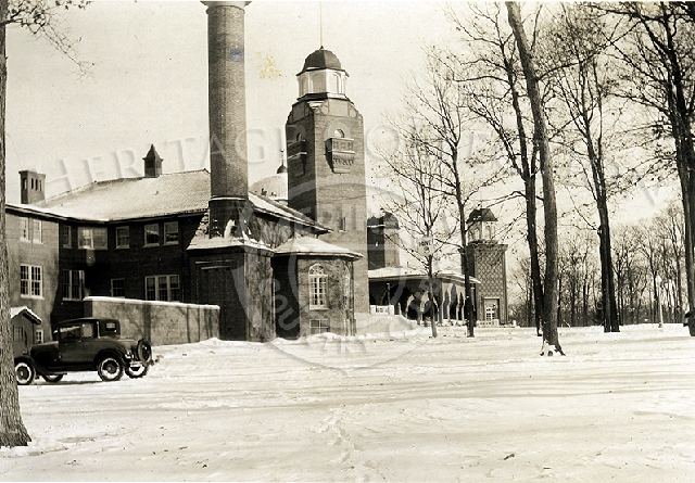 Winter scene of clubhouse east view w/car parked.