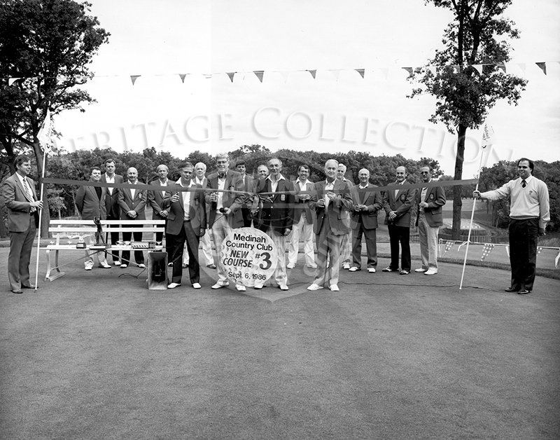 Dedication of Course No. 3, hole 17 & 18. A total of 16 men are standing during the 1986 ribbon cutting ceremony.