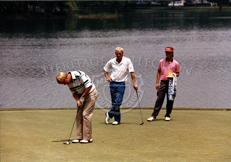Left to right: Jack Nicklaus lines up a putt as Greg Norman leans on his putter waiting  his turn during the 90th U.S. Open championship. Norman faired better, tying for 5th place with Tim Simpson and Mark Brooks. Nicklaus did not make the top ten listing.