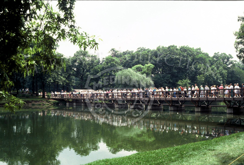 Spectators walking across one of Medinah Country Club's four bridges that extend over Lake Kadijah. The scene is from the 90th U.S. Open Championship.