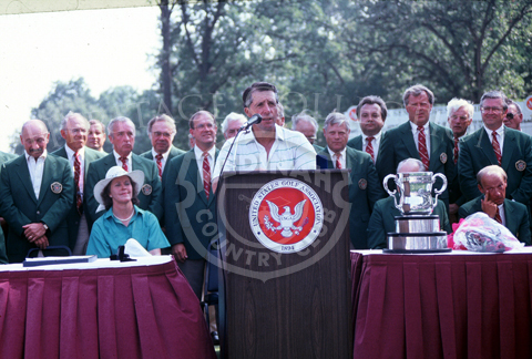 Gary Player, at the podium, speaks to the media and public after winning the Ninth U.S. Senior Open Championship in 1988. Upon completion of the 18-hole playoff round on August 9th, Player defeated Bob Charles with a 4-under par.  Note the Francis D. Ouimet trophy sitting on the table.