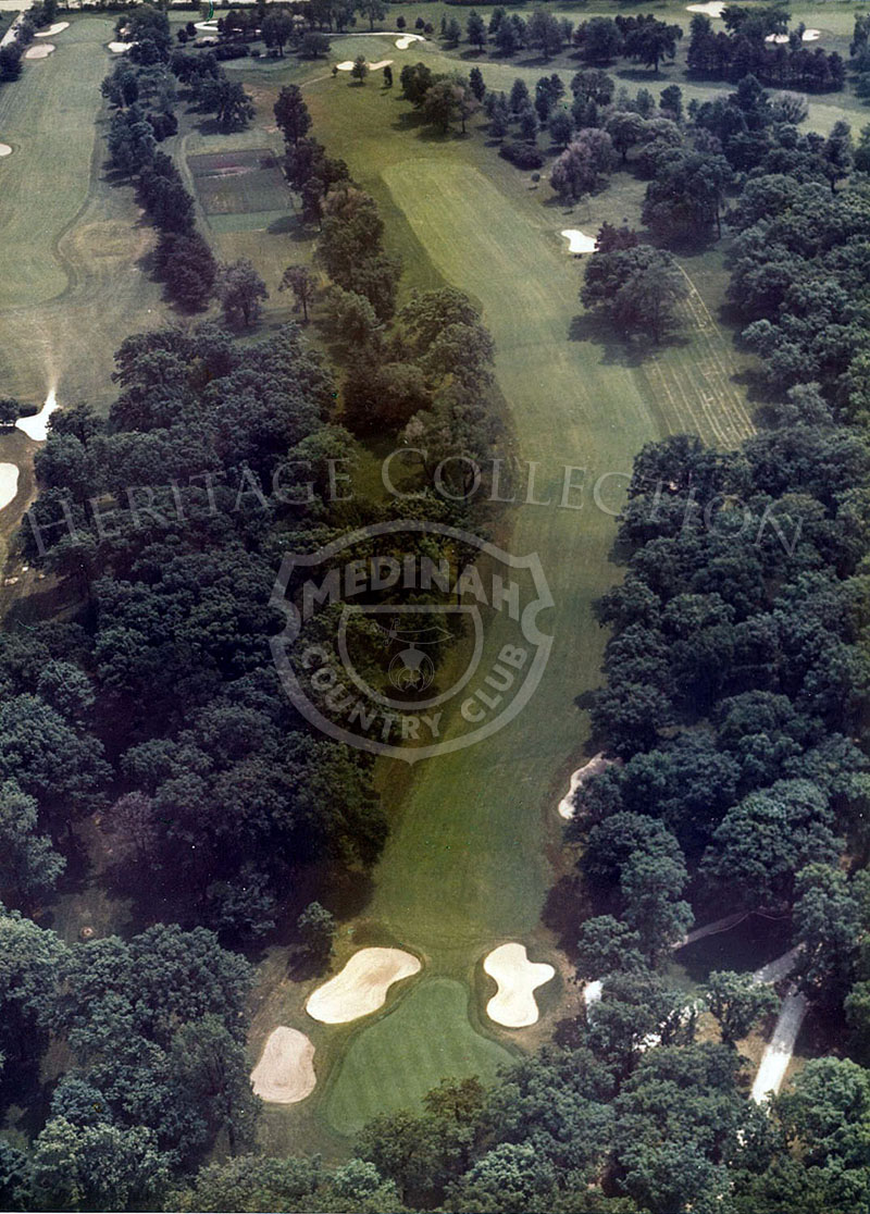 1975 Aerial view of Hole 7 of Course No. 3. The 594-yard par-5 seventh hole, dog legging right around dense trees to a severely sloping green, is one of the most testing holes on the course.