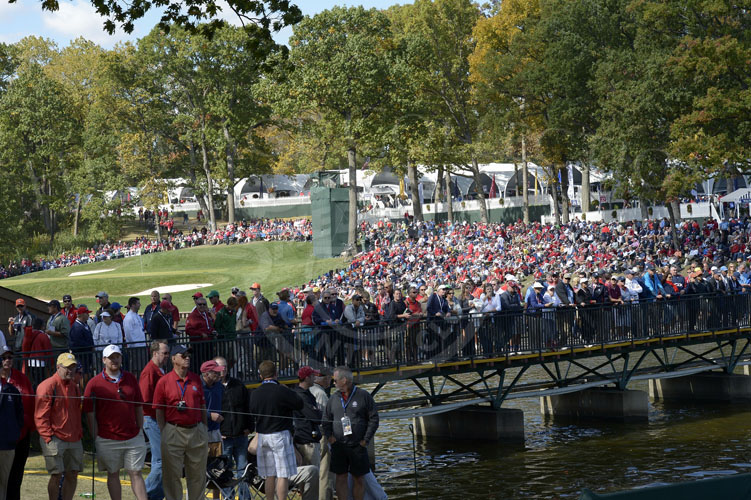 Crowds gathered on the bridge crossing to hole #2, with the 13th hole in the background.